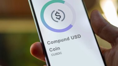 Bir değiş tokuş ekranında USD Coin 'in logosuna yaklaş. (CUSDC) Bir aygıt üzerinde USD madeni para fiyatları hisse senetleri, $CUSDC.