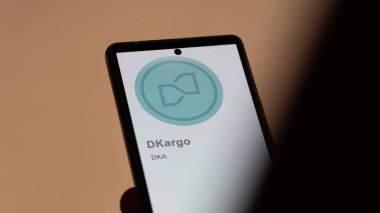 Bir değiş tokuş ekranında dKargo (DKA) logosunu kapat. (DKA) dKargo fiyat hisseleri, bir aygıt üzerinde $DKA.