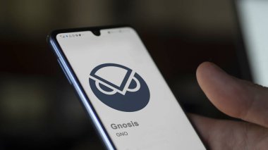 Değiş tokuş ekranındaki Gnosis logosuna yaklaş. (GNO) Gnosis fiyat hisseleri, bir cihaza GNO $.