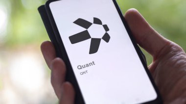 Bir takas ekranındaki (QNT) quant logosuna yaklaş. Quant fiyat hisseleri, bir aygıta QNT $.