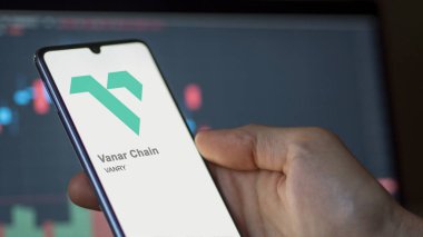 Vanar Zinciri 'nin logosuna yakın çekim bir takas ekranında. Vanar Chain hisse senetleri, bir cihaza VANRY $.