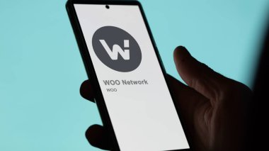 Bir değiş tokuş ekranındaki WOO Ağı 'nın logosunu kapat. WOO Ağ Fiyat Hisseleri, Bir cihaza $WOO.