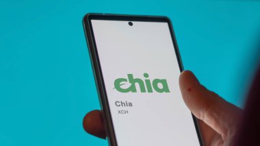 Bir değiş tokuş ekranındaki Chia logosuna yaklaş. Chia fiyat hisseleri, bir cihazda XCH $.