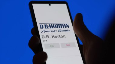 09 Nisan 2024, Arlington, Teksas. D.R. logosunu kapat. Horton bir değiş tokuş ekranında. D R Horton hisse senetleri, DHI $bir aygıt üzerinde.