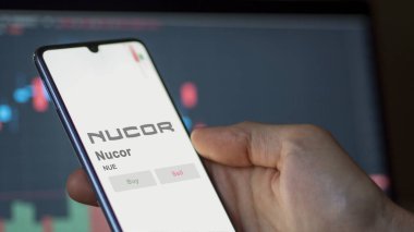 09 Nisan 2024, Charlotte, Kuzey Carolina. Değiş tokuş ekranında Nucor 'un logosuna yaklaş. Nucor fiyat hisseleri, bir aygıtta NUE $.