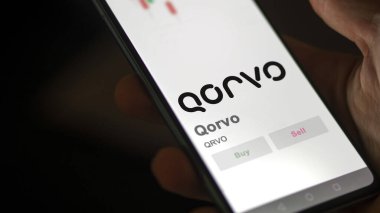 09 Nisan 2024, Greensboro, Kuzey Carolina. Takas ekranındaki Qorvo logosuna yaklaş. Qorvo hisse senetleri, bir cihazda QRVO $.