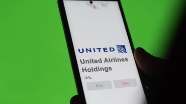 29 Nisan 2024, Chicago, Illinois. Bir değiş tokuş ekranındaki United Airlines Holding logosuna yaklaş. United Airlines Holding hisse senetleri, bir cihaza UAL $.