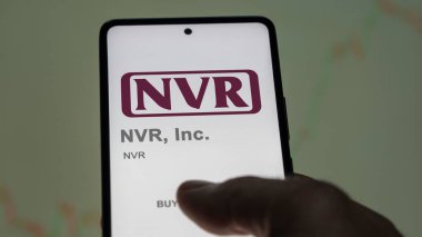 29 Nisan 2024, Reston, Virginia. Değiş tokuş ekranındaki NVR Inc. 'nin logosuna yaklaş. NVR, Inc fiyat hisseleri, bir aygıtta NVR $.