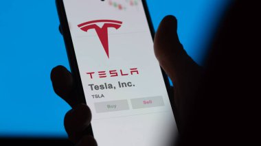 09 Nisan 2024, Austin, Teksas. Tesla A.Ş. 'nin logosuna bir değiş tokuş ekranında yaklaş. Tesla, Inc. Fiyat hisseleri, bir cihaza TSLA $.