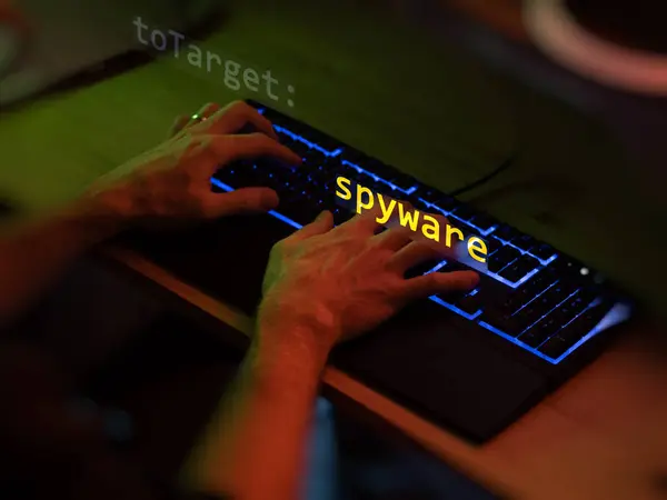 stock image Cyber attack spyware text in foreground screen, hands of a anonymous hacker on a led keyboard. Vulnerability text in informatic system style, code on editor screen. Text in English, English text