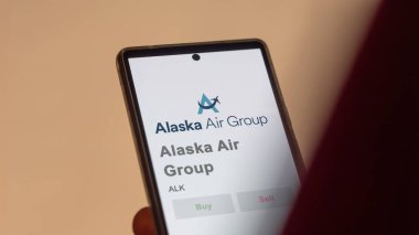 29 Nisan 2024, SeaTac, Washington. Bir değiş tokuş ekranında Alaska Hava Grubu 'nun logosuna yaklaş. Alaska Hava Grubu hisse senetleri, bir cihaza ALK $..