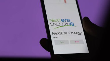 29 Nisan 2024, Juno Sahili, Florida. Değiş tokuş ekranındaki NextEra Enerji logosuna yaklaş. NextEra Enerji Fiyat Hisseleri, Bir aygıt için $NEE.