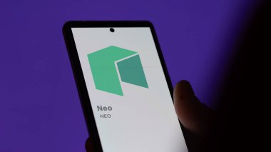 17 Nisan 2024, Şangay, Çin. Bir değiş tokuş ekranında (NEO) Neo logosuna yaklaş. (NEO) Neo fiyat hisseleri, bir cihaza $NEO.