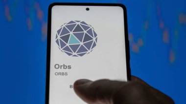 17 Nisan 2024, Şangay, Çin. Değiş tokuş ekranındaki kürelerin logosuna yaklaş. Küreler hisse senedi fiyatları, bir cihazda ORBS $.