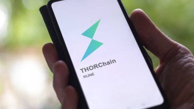 17 Nisan 2024, Şangay, Çin. Değiş tokuş ekranındaki THORChain logosunu kapat. THORChain hisse senetleri, bir cihaza harcanan para..