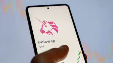 17 Nisan 2024, Şangay, Çin. Değiş tokuş ekranındaki UNI uniswap logosuna yaklaş. (UNI) Uniswap fiyat hisseleri, bir cihaza UNI $.