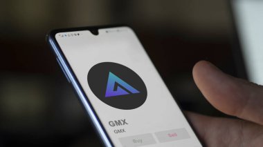 Değiş tokuş ekranındaki GMX GMX logosuna yaklaş. GMX GMX fiyat hisseleri, bir aygıta GMX $.
