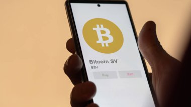 Close up on logo of BSV Bitcoin SV on the screen of an exchange. BSV Bitcoin SV price stocks, $BSV on a device. clipart