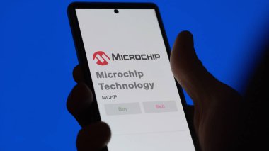 29 Nisan 2024, Chandler, Arizona. Mikroçip Teknolojisi 'nin logosuna bir değiş tokuş ekranında yaklaş. Mikroçip Teknoloji hisse senetleri, bir cihaza $MCHP.