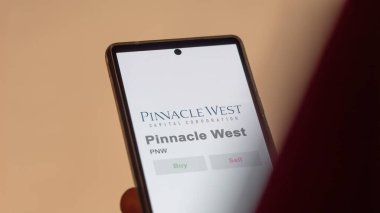 09 Nisan 2024, Phoenix, Arizona. Takas ekranındaki Pinnacle West logosuna yaklaş. Zirve Batı fiyat hisseleri, bir aygıt için PNW $.