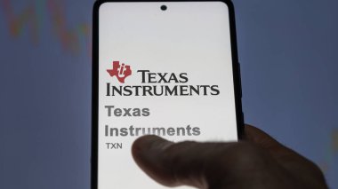 09 Nisan 2024, Dallas, Teksas. Bir değiş tokuş ekranındaki Teksas Aletleri logosuna yaklaş. Texas Instruments hisse senedi fiyatları, bir cihaza TXN $.