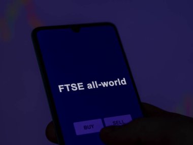 Bir yatırımcı ekranda ftse tüm dünya etf fonunu analiz ediyor. FTSE 'nin tüm dünyadaki fiyatlarını gösteren bir telefon