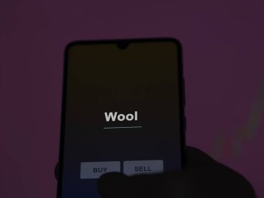 Bir yatırımcı ekranda yün etf fonunu analiz ediyor. Bir telefon yün fiyatlarını gösterir