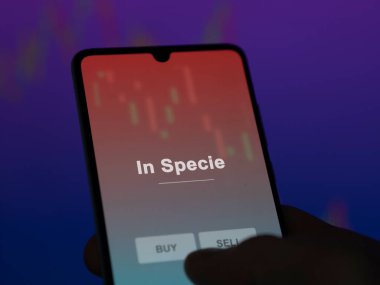 Bir yatırımcı ekrandaki spekülasyon fonunu analiz ediyor. Bir telefon In Specie 'nin fiyatlarını gösterir