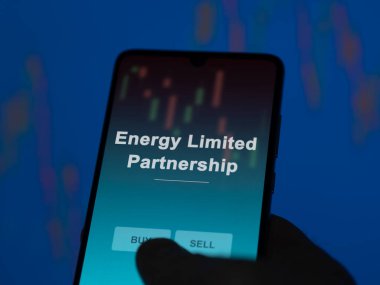Ekranda enerji sınırlı ortaklık fonunu analiz eden bir yatırımcı. Enerji Sınırlı Ortaklığı 'nın fiyatlarını gösteren bir telefon