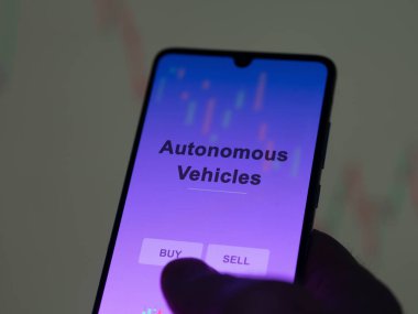 An investor analyzing the autonomous vehicles etf fund on a screen. A phone shows the prices of Autonomous Vehicles clipart