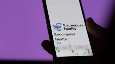 26 Mart 2024, Encompass Health logosu. Salon binasının beyaz bir duvarında, EHC markası..