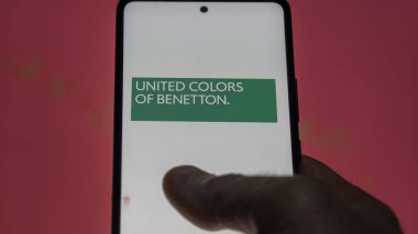 Bir yatırımcı ekranda Benetton Grup Etf fonunu analiz ediyor. Benetton Grup 'un fiyatlarını gösteren bir telefon.