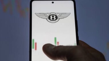 Ekranda Bentley ETF fonunu analiz eden bir yatırımcı. Bentley 'in fiyatlarını gösteren bir telefon