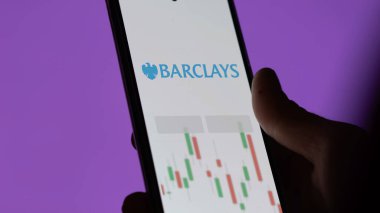 Barclays etf fonunu ekranda analiz eden bir yatırımcı. Barclays fiyatlarını gösteren bir telefon