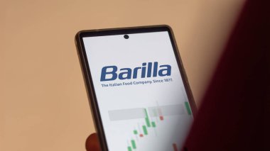 Ekranda Barilla (şirket) etf fonunu analiz eden bir yatırımcı. Barilla 'nın fiyatlarını gösteren bir telefon (şirket))