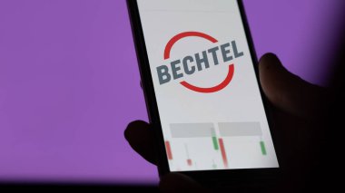 Bir yatırımcı ekrandaki Becktel Fonu 'nu analiz ediyor. Bechtel 'in fiyatlarını gösteren bir telefon.