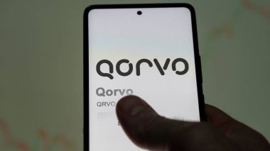Greensboro, Kuzey Carolina. Takas ekranındaki Qorvo logosuna yaklaş. Qorvo hisse senetleri, bir cihazda QRVO $.