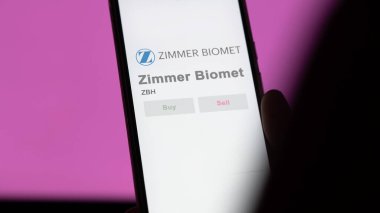 Varşova, Indiana. Değiş tokuş ekranındaki Zimmer Biomet logosuna yaklaş. Zimmer Biyomet hisse senetleri, bir cihaza ZBH $..
