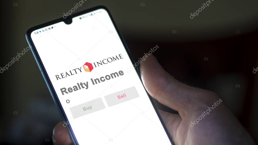 San Diego, California. Close up on logo of Realty Income on the screen of an exchange. Realty Income price stocks, $O on a device.