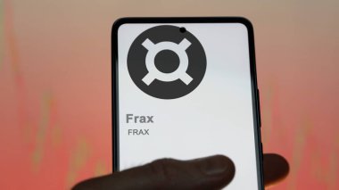 Bir değiş tokuş ekranındaki FRAX Frax kripto varlığının logosuna yaklaş. FRAX Frax fiyat hisseleri, bir aygıt üzerinde FRAX $.