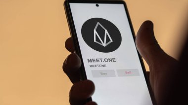 Bir değiş tokuş ekranında MEETON MEETON 'un şifreli varlığının logosuna yaklaş. MEETON BİR Fiyat hisselerini karşıladı, Bir aygıtta $MEETone.