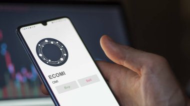 Bir değiş tokuş ekranındaki OMI ECOMI kripto varlığının logosuna yaklaş. OMI ECOMI hisse senetleri, OMI $on a device.