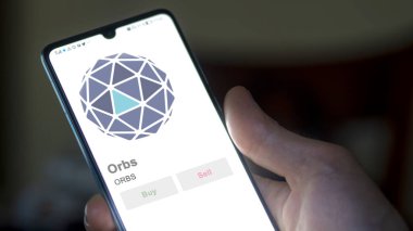 Bir değiş tokuş ekranındaki ORBS Küre Kripto varlığının logosuna yaklaş. ORBS Küreleri hisse senetleri, bir aygıt üzerinde ORBS $.