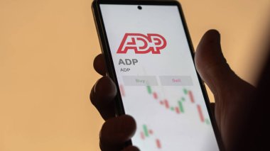 Roseland, New Jersey 'de. Değiş tokuş ekranındaki ADP logosuna yaklaş. ADP hisse senetleri, cihaza ADP $.