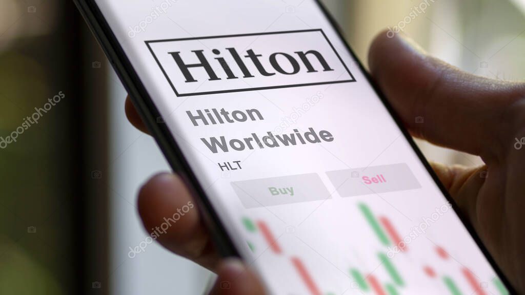 Tysons Corner, Virginia. Close up on logo of Hilton Worldwide on the screen of an exchange. Hilton Worldwide price stocks, $HLT on a device.