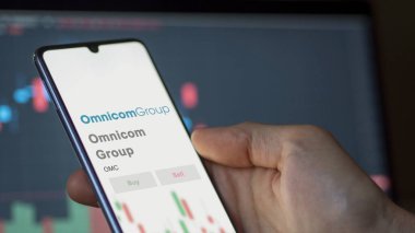 New York, New York. Omnicom Grubu 'nun logosuna bir takas ekranında yaklaş. Omnicom Grubu hisse senetleri, bir aygıt üzerinde $OMC.