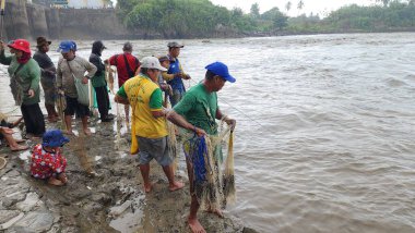 Pinrang Endonezya, 12 Temmuz 2023: Pinrang Fort 'ta yaşayan binlerce kişi, baraj kapısı sabah temizlenmek üzere açıldığında balık ve karides yakalamakla meşguller.