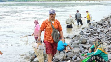 Pinrang Endonezya, 12 Temmuz 2023: Pinrang Fort 'ta yaşayan binlerce kişi, baraj kapısı sabah temizlenmek üzere açıldığında balık ve karides yakalamakla meşguller.