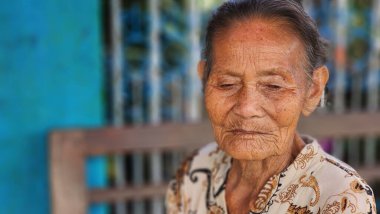 Pinrang Endonezya, 28 Temmuz 2023: Masolo Pinrang Endonezya köyünde sabah yaşlı bir anne kameraya poz verirken şaşkın ve şaşkın bir yüzle salonda oturuyor.