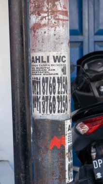 Pinrang, Endonezya 19 Eylül 2023: Tuvalet Uzmanı Hizmetleri, bazı çıkmaz sokak tuvalet hizmetleri elektrik direklerinin önüne ilanlar koyuyor, öğleden sonra, Asya Endonezya